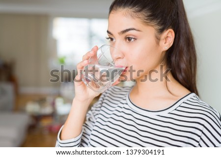 Beautiful young woman drinking a fresh glass of water at home Foto d'archivio © 