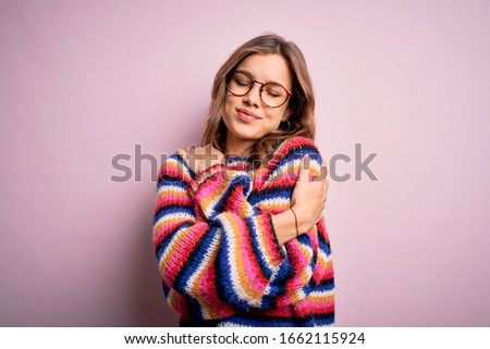 Young beautiful blonde girl wearing glasses and casual sweater over pink isolated background Hugging oneself happy and positive, smiling confident. Self love and self care Сток-фото © 