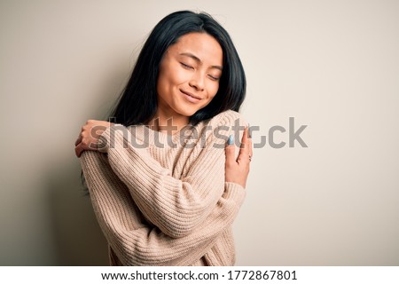 Young beautiful chinese woman wearing casual sweater over isolated white background Hugging oneself happy and positive, smiling confident. Self love and self care Сток-фото © 