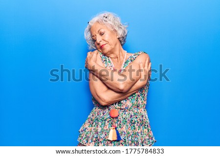 Senior grey-haired woman wearing casual clothes hugging oneself happy and positive, smiling confident. self love and self care  Сток-фото © 