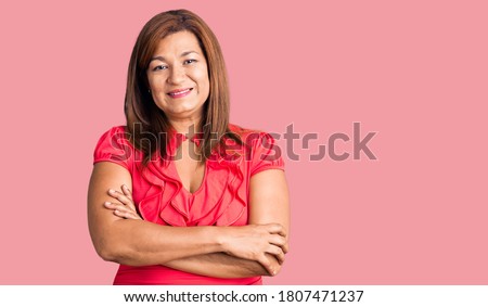 Middle age latin woman wearing casual clothes happy face smiling with crossed arms looking at the camera. positive person.  商業照片 © 