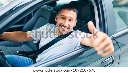 Young hispanic man smiling happy doing ok sign driving car. Stock foto © 