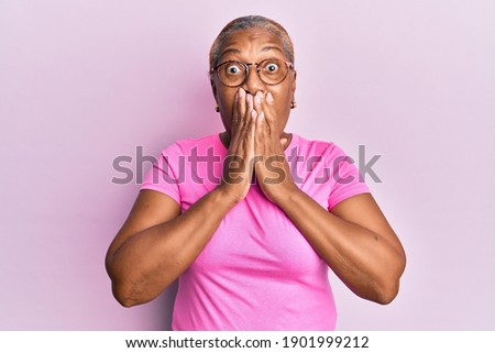 Senior african american woman wearing casual clothes and glasses shocked covering mouth with hands for mistake. secret concept.  商業照片 © 