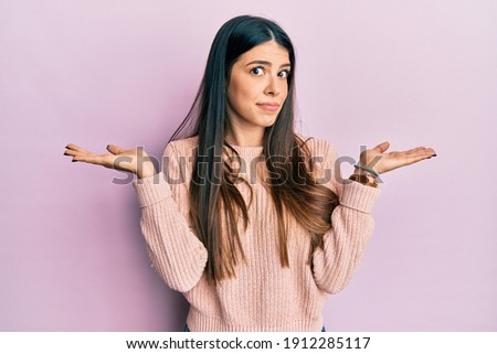 Young hispanic woman wearing casual clothes clueless and confused with open arms, no idea and doubtful face. 