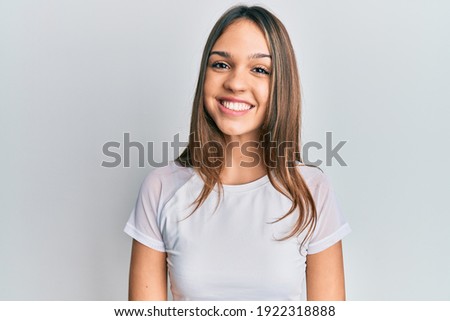 Young brunette woman wearing casual white t shirt with a happy and cool smile on face. lucky person. 