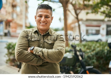 Young latin man with arms crossed smiling happy at the city. 商業照片 © 