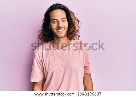 Similar – Image, Stock Photo Long haired young handsome man on a black background with a light illuminating his face, with a flirtatious expression for the camera showing a slight smile