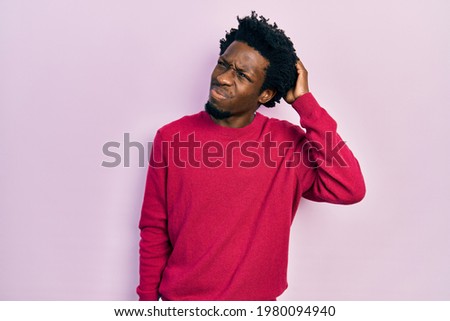 Young african american man wearing casual clothes confuse and wondering about question. uncertain with doubt, thinking with hand on head. pensive concept.  Foto stock © 