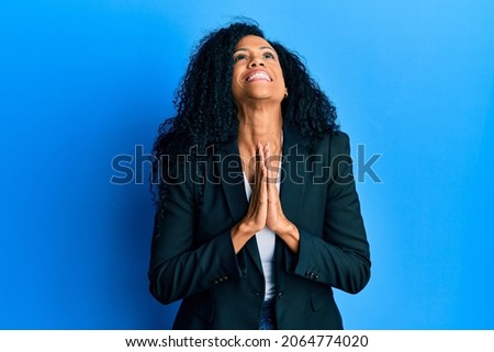 Middle age african american woman wearing business clothes begging and praying with hands together with hope expression on face very emotional and worried. begging.  商業照片 © 