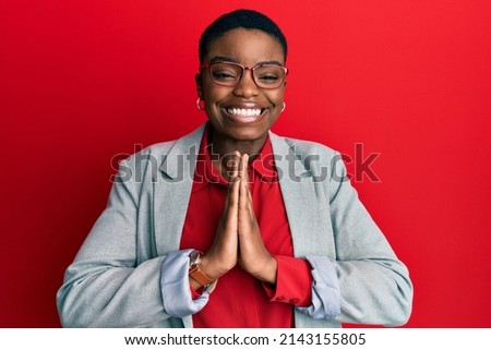 Young african american woman wearing business jacket and glasses begging and praying with hands together with hope expression on face very emotional and worried. begging.  Foto d'archivio © 