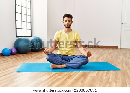 Man training yoga on beach