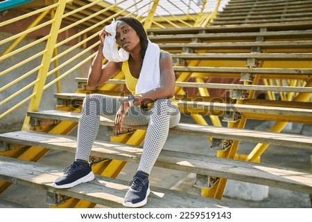 Similar – Image, Stock Photo Serious black sportswoman sitting on stone border in city