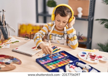 Image, Stock Photo Child sitting with headphones on a sofa with tablet computer looking frontally at night