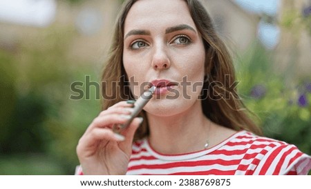 Image, Stock Photo Modern relaxed woman vaping while sitting on marked road