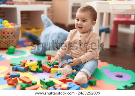 Similar – Image, Stock Photo Toddler playing with a colorful plastic bug toy; using hands to manipulate small object developmental milestone