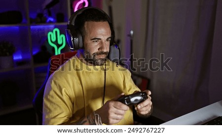 Image, Stock Photo Man playing video game at home. Gamer playing online in dark room lit by neon lights. Competition and having fun