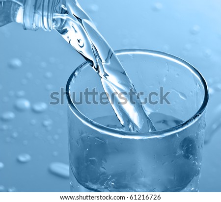 bottle pouring water on a glass
