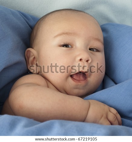 baby hide under a blue blanket extreme closeup
