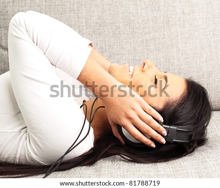 woman listen to music resting on the sofa