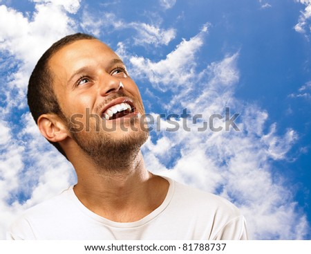 lucky man laughing looking up on a sky background