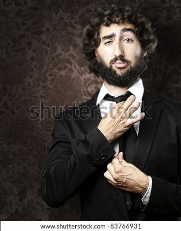 portrait of young man adjusting his suit against a grunge background