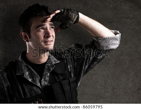 young soldier looking forward against a grunge wall