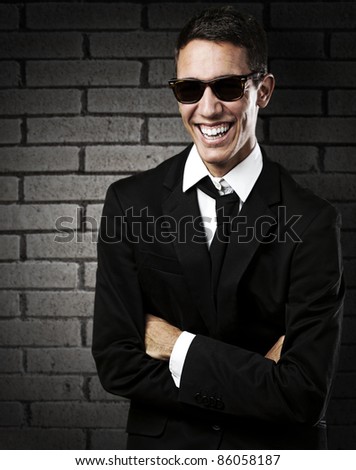 portrait of young business man with suit and smiling against a grunge wall