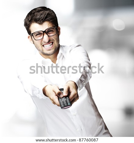 portrait of young man changing channel with tv control indoor