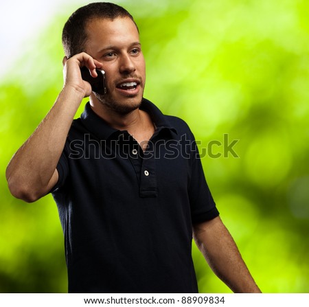 young man talking on mobile phone against a nature background