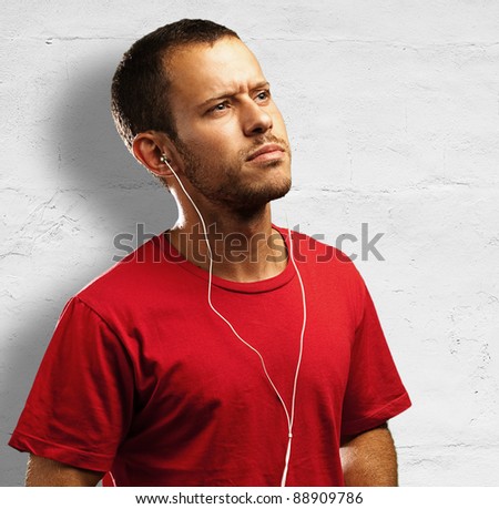 young man listen to music against a white wall background