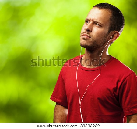 young man listen to music against a plants background