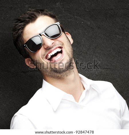 portrait of a handsome young man enjoying against a grunge wall