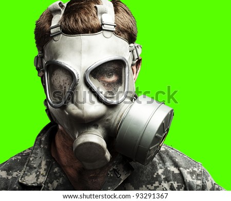 portrait of a young soldier wearing a gas mask against a removable chroma key background