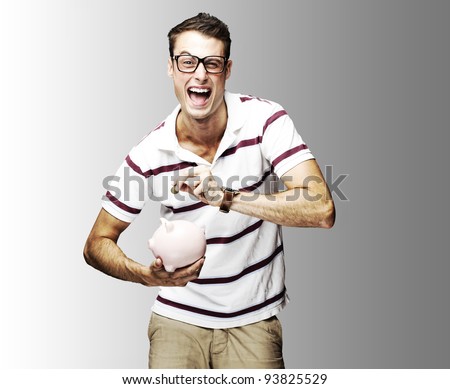portrait of a crazy man saving money in a piggy bank against a grey background