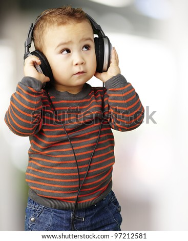 portrait of a handsome kid listening to music looking up indoor