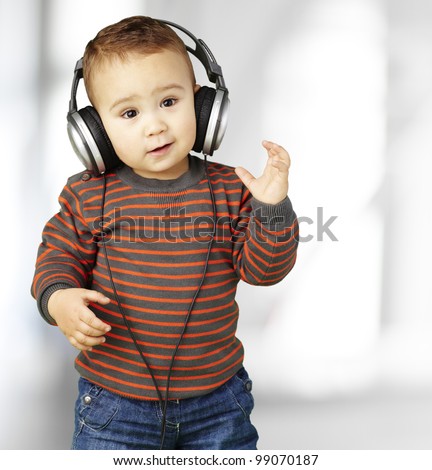 portrait of adorable kid with headphones listening to music indoor