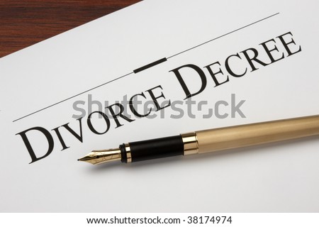 Divorce decree and gold fountain pen shot on warm wood surface