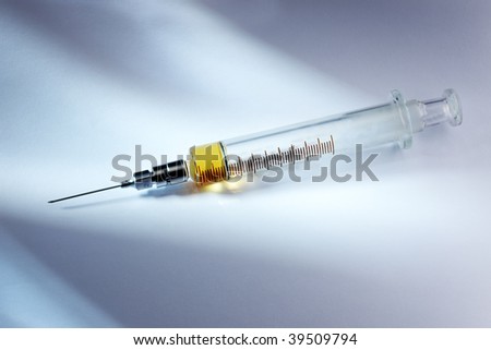 medicine loaded into syringe shot on white background with light streaming across frame leaving dramatic shadows