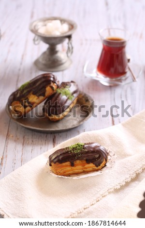 Delicious and beautiful chocolate small cake ekler pastry and tea. Stok fotoğraf © 