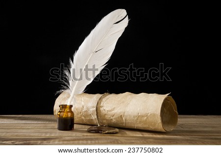 old paper and feather on a black background