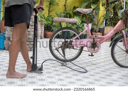 Similar – Image, Stock Photo Woman inflating bicycle tire in workshop
