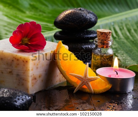 Cheese block and orange slice resting on a table with basalt stones and oils for a spa break