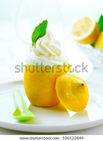 Fresh creamy icecream served as a topping on a sliced fresh lemon for a cool refreshing dessert