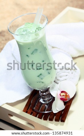 Photo of a chilled wellness delicious looking drink with towels in white tray on the beach.
