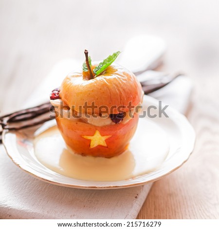 Scary Halloween dessert, a baked stuffed apple decorated with a star and cut out gaping mouth showing teeth garnished with fresh mint