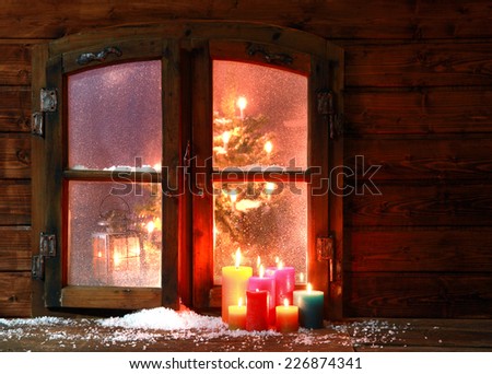 Small Amount of Snow and Lighted Colored Candles at Vintage Window Pane During Christmas Season.