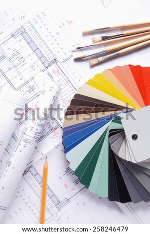 Close up Color Palette Guide Fan, Paint Brushes and Yellow Pencil on Top of a House Blueprint