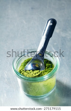 Jar of matcha powder, or Japanese powdered green tea used in tea ceremonies and as a flavoring in drinks