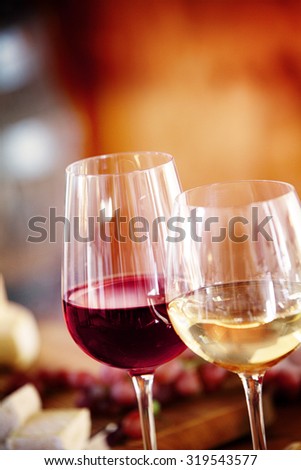 Glasses of red and chilled white wine on a dining table with background blur copyspace, close up view of the beverage
