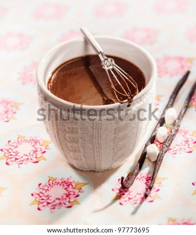 White ceramic cup of delicious thick whisked melted chocolate with vanilla pods and sugar